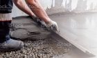 Worker levels a floor cement mortar. Equal floor. Repair of the house.